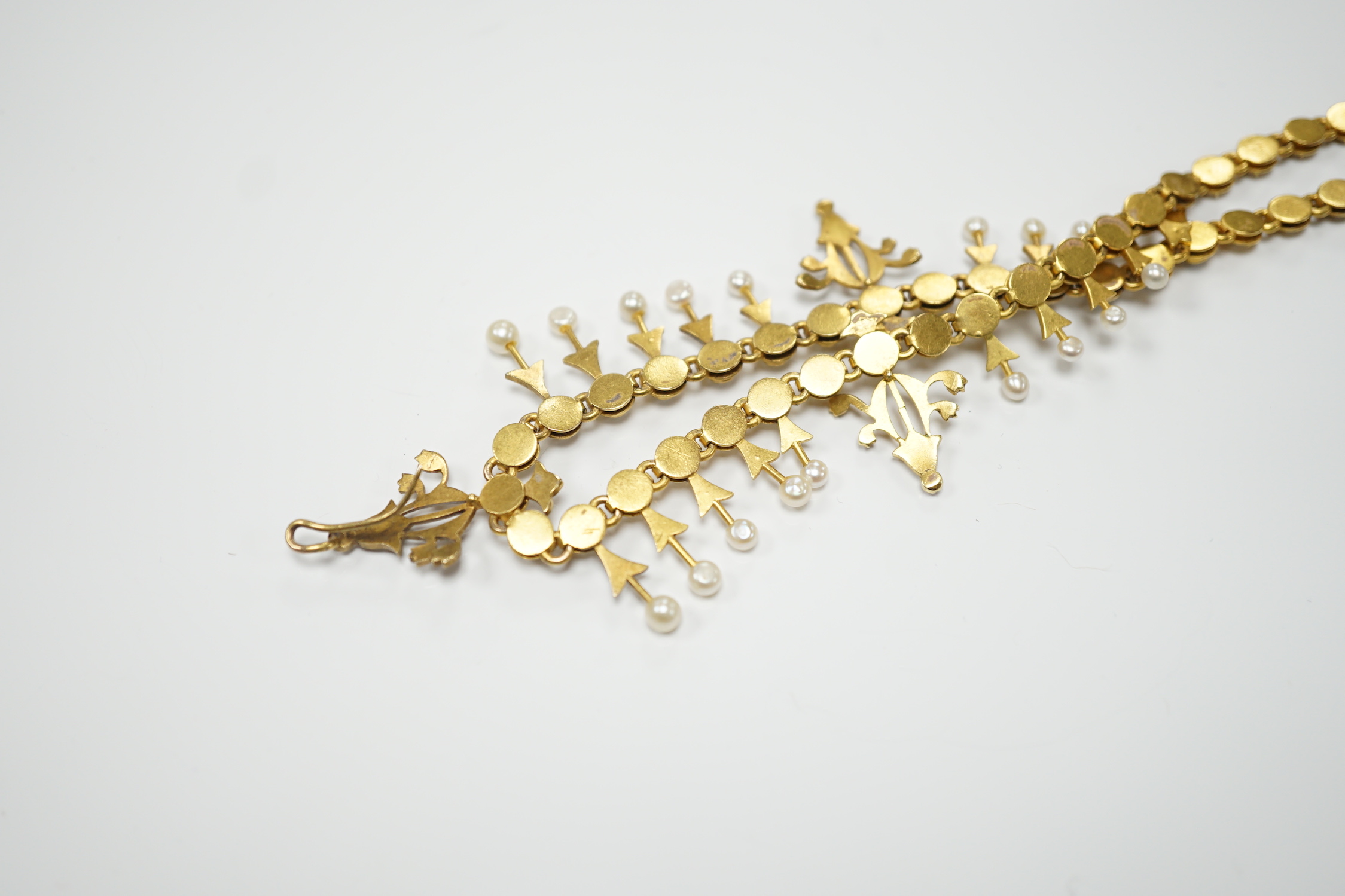 An Edwardian yellow metal and seed pearl set necklace, lacking drops and clasp, 39cm, gross weight 26.2 grams.
